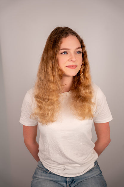 Person wearing a white t-shirt and blue jeans against a plain background