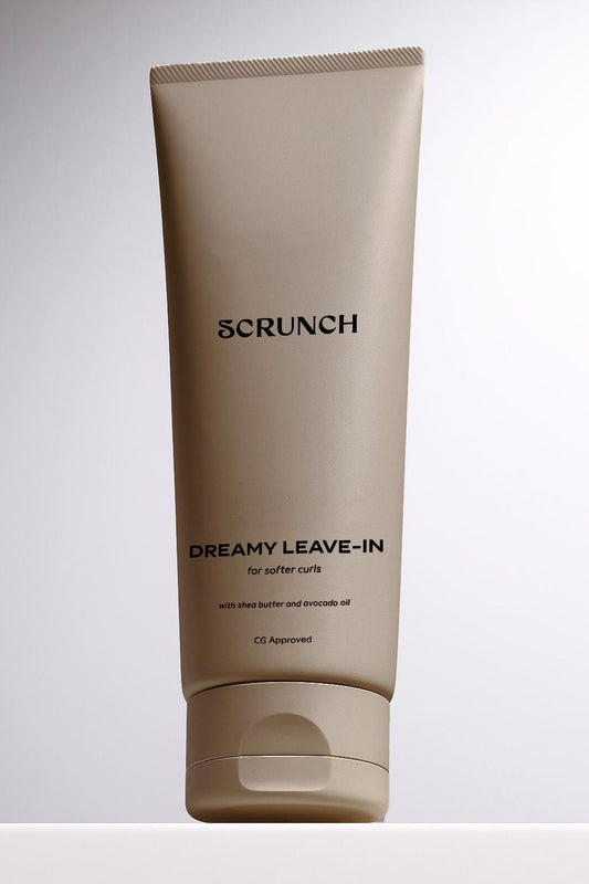 Tube of 'Scrunch Dreamy Leave-In' product on a light gray background